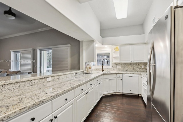 kitchen with white dishwasher, sink, stainless steel fridge, and white cabinetry