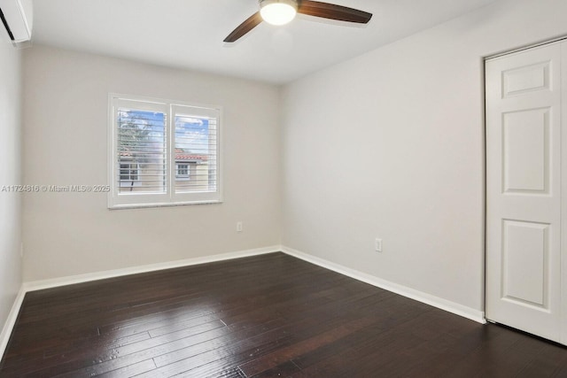 empty room with ceiling fan, dark hardwood / wood-style flooring, and a wall unit AC