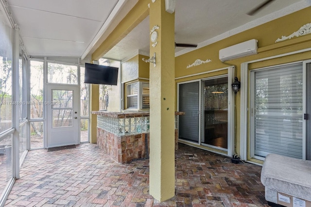 unfurnished sunroom with ceiling fan and a wall mounted air conditioner