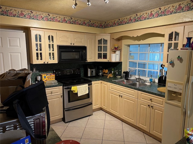 kitchen featuring stainless steel electric stove, a textured ceiling, white refrigerator with ice dispenser, sink, and light tile patterned flooring