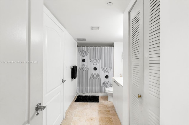 bathroom featuring toilet, a shower with shower curtain, and vanity