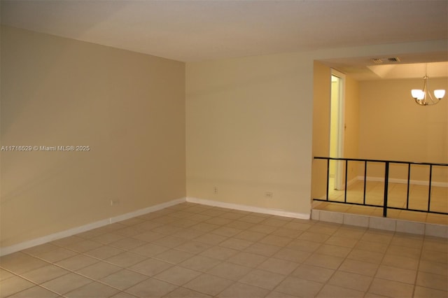 unfurnished room with light tile patterned floors and a chandelier