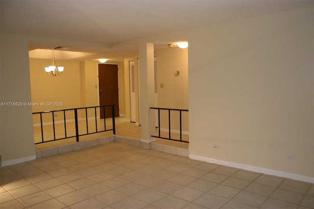 tiled empty room with a chandelier