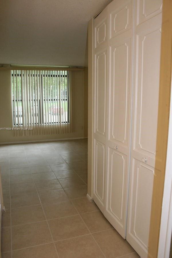 hallway with light tile patterned floors and a wealth of natural light