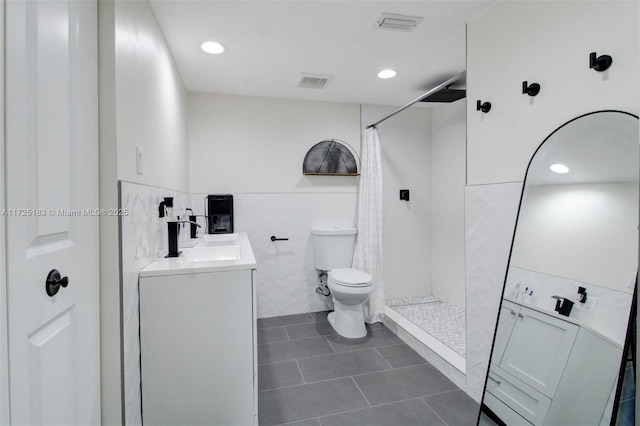 bathroom featuring toilet, a shower with shower curtain, vanity, and tile patterned floors