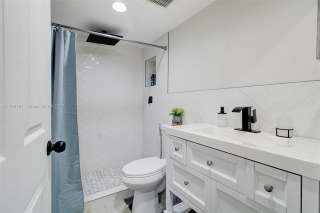 bathroom with toilet, vanity, tile walls, decorative backsplash, and curtained shower