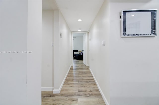 corridor with light hardwood / wood-style floors