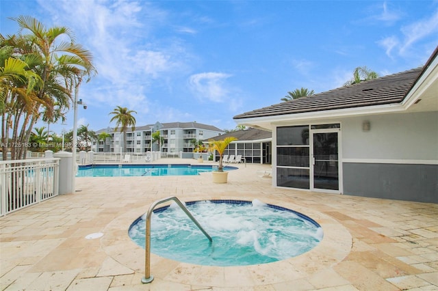 view of swimming pool with a patio area and a hot tub