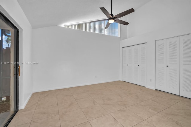 unfurnished bedroom with ceiling fan, light tile patterned floors, access to exterior, and multiple closets