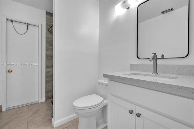 bathroom with toilet, tile patterned floors, and vanity