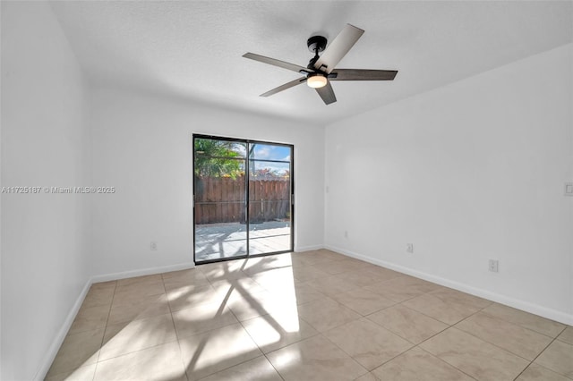 empty room with ceiling fan and light tile patterned floors