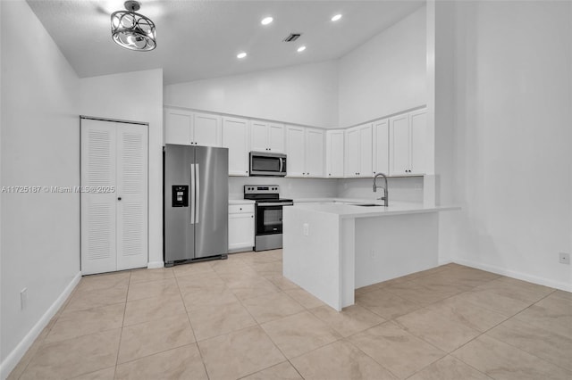 kitchen with sink, white cabinetry, kitchen peninsula, high vaulted ceiling, and appliances with stainless steel finishes