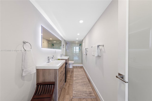 bathroom featuring walk in shower, toilet, vanity, and hardwood / wood-style flooring