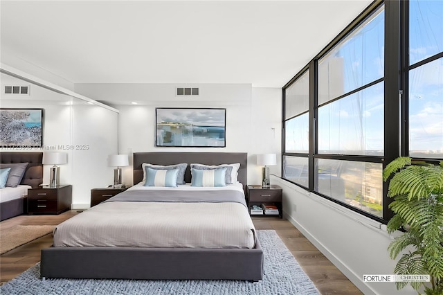 bedroom with multiple windows and wood-type flooring