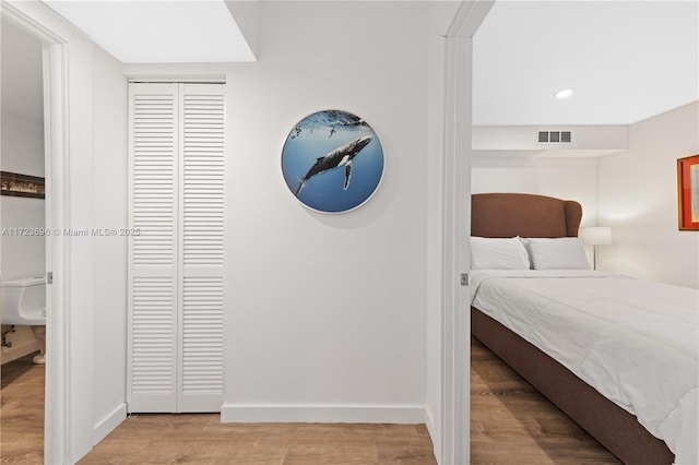 bedroom featuring light hardwood / wood-style floors and a closet