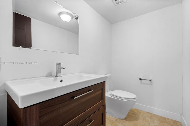 bathroom with toilet, tile patterned floors, and vanity