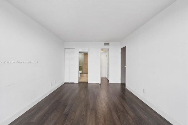 unfurnished room with dark wood-type flooring