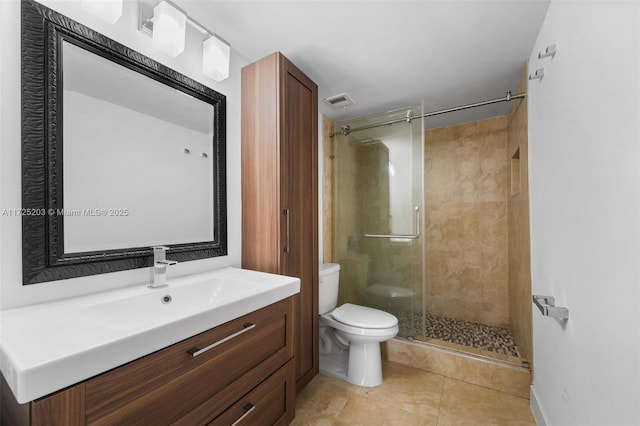 bathroom featuring toilet, a shower with door, vanity, and tile patterned flooring