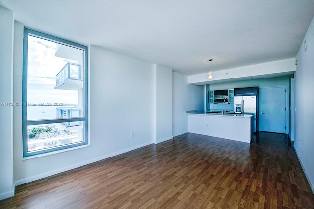 unfurnished living room featuring dark wood-type flooring and sink