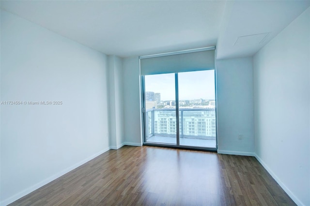 empty room featuring dark hardwood / wood-style flooring and a wall of windows