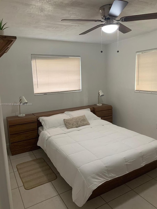 bedroom with ceiling fan and light tile patterned floors