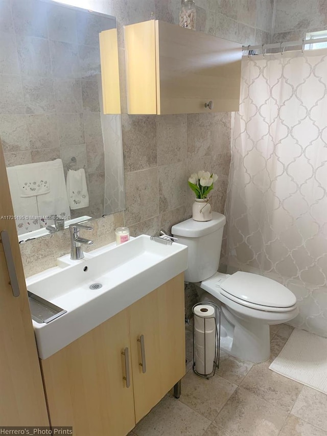 bathroom with tile walls, decorative backsplash, vanity, and toilet