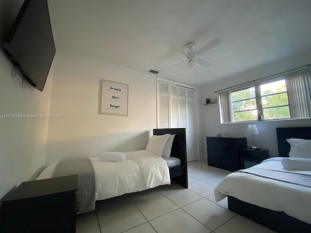 bedroom with a closet, ceiling fan, and light tile patterned floors