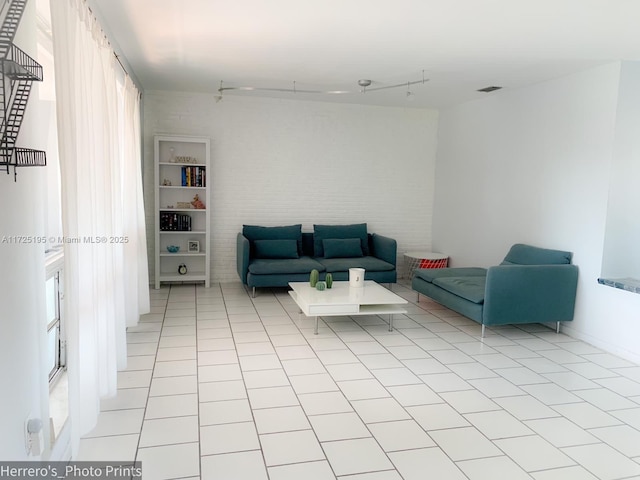 living room featuring rail lighting and light tile patterned floors