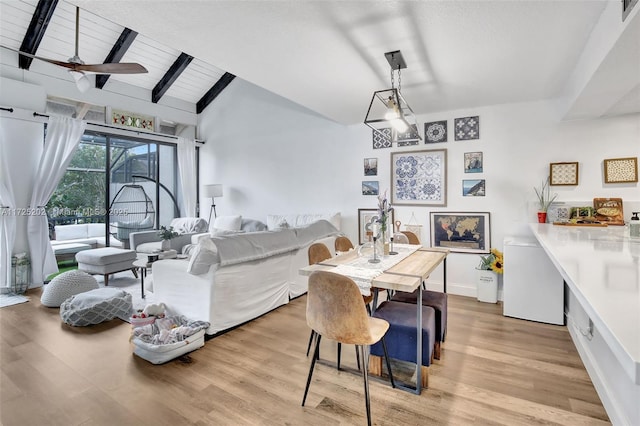 dining space with ceiling fan, light hardwood / wood-style flooring, and vaulted ceiling with beams