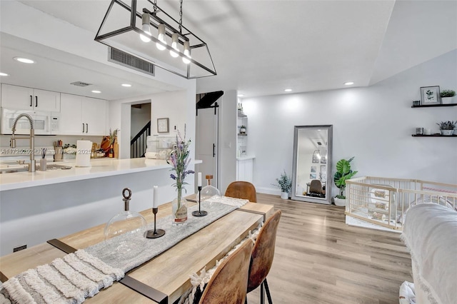 dining area featuring sink and light hardwood / wood-style floors