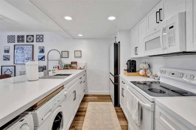 kitchen featuring white appliances, white cabinets, sink, and hardwood / wood-style flooring