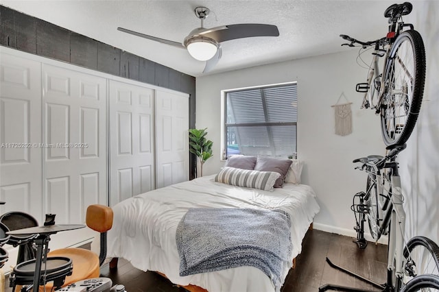 bedroom with ceiling fan, a closet, a textured ceiling, and dark hardwood / wood-style floors