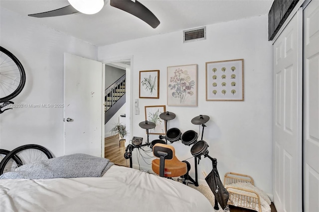 bedroom featuring wood-type flooring, ceiling fan, and a closet