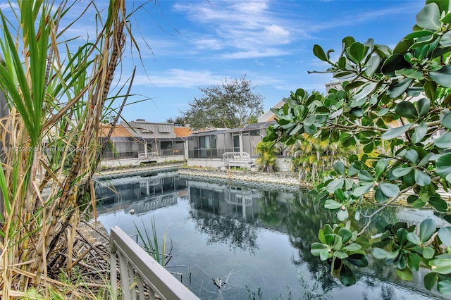 view of swimming pool with glass enclosure and a water view