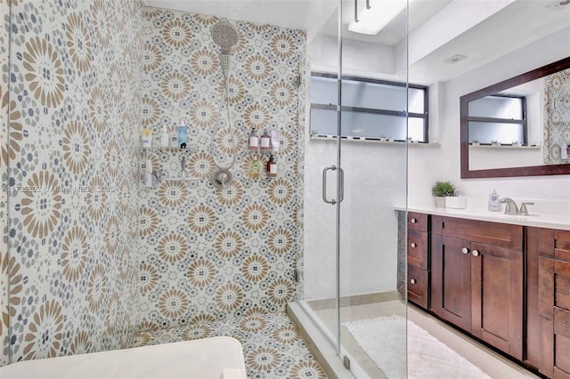 bathroom with a shower with door, tile patterned flooring, and vanity