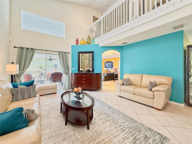 tiled living room with a high ceiling and ceiling fan