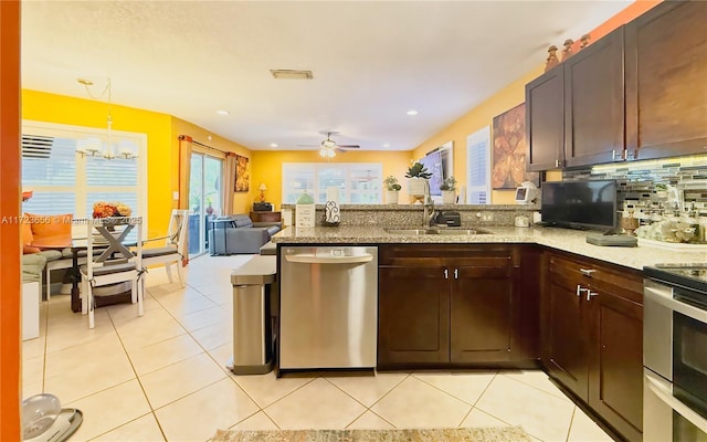 kitchen featuring stainless steel dishwasher, pendant lighting, decorative backsplash, ceiling fan with notable chandelier, and sink