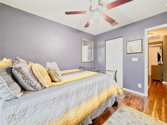 bedroom featuring ceiling fan, a closet, and hardwood / wood-style flooring