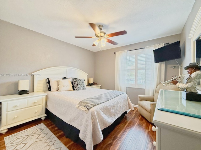 bedroom with ceiling fan and dark wood-type flooring