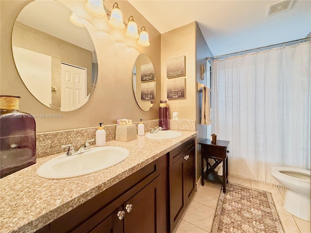 bathroom featuring walk in shower, vanity, tile patterned floors, and toilet