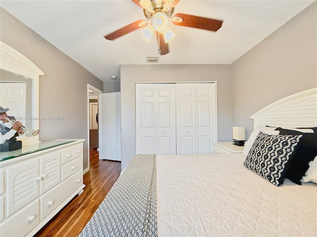 bedroom with dark hardwood / wood-style flooring, a closet, and ceiling fan