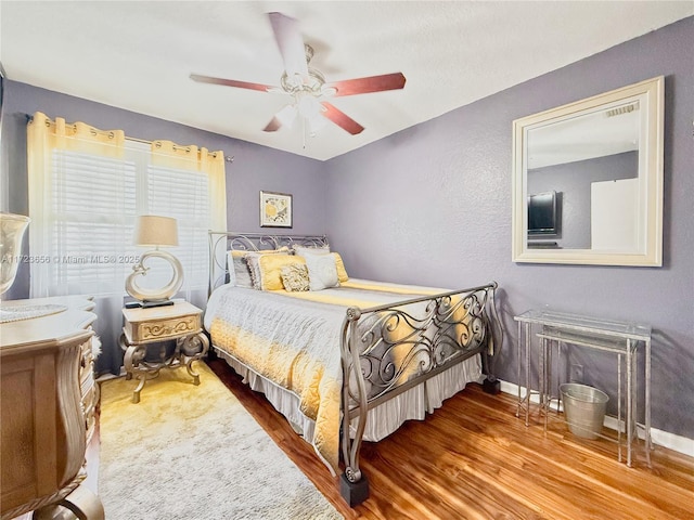 bedroom with ceiling fan and hardwood / wood-style flooring