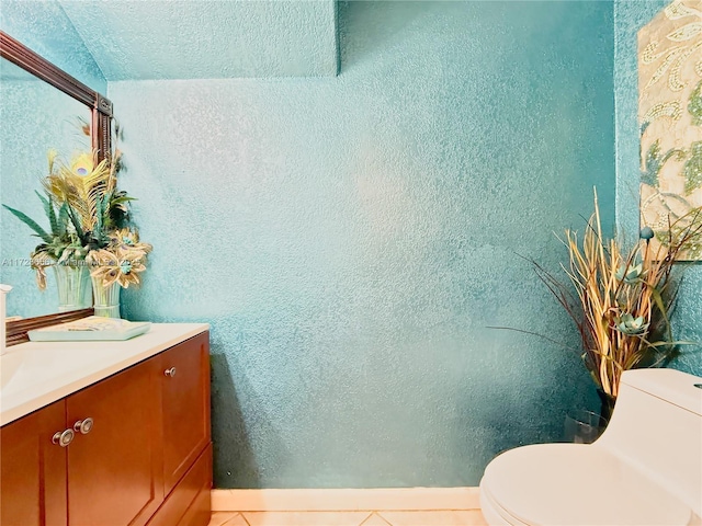 bathroom with tile patterned flooring, vanity, and toilet