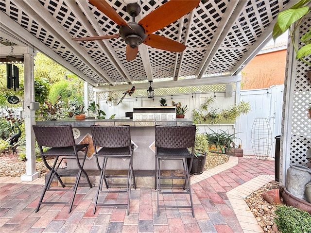 view of patio with a bar, ceiling fan, and area for grilling