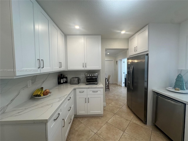 kitchen with stainless steel refrigerator with ice dispenser, decorative backsplash, white cabinetry, and refrigerator