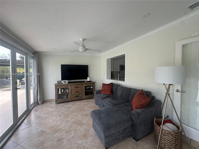 tiled living room featuring ceiling fan, french doors, ornamental molding, and a textured ceiling