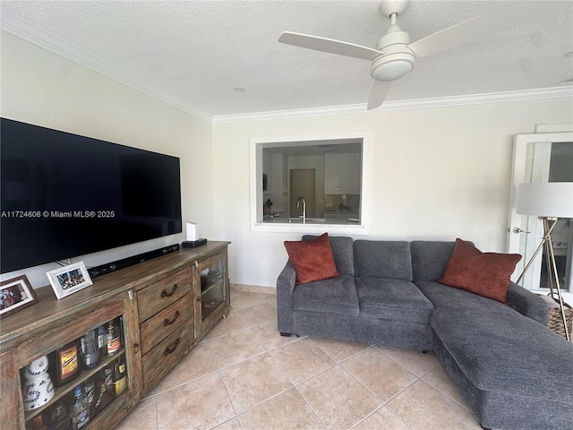 tiled living room with a textured ceiling, ceiling fan, ornamental molding, and sink