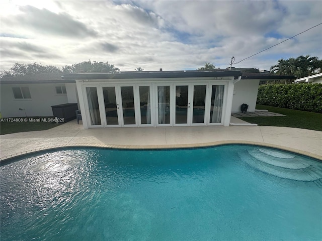 view of swimming pool featuring french doors and a patio