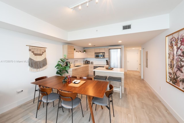 dining area featuring light hardwood / wood-style floors and sink