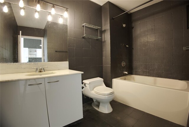 bathroom with tile walls, shower / bathtub combination, toilet, vanity, and tile patterned flooring